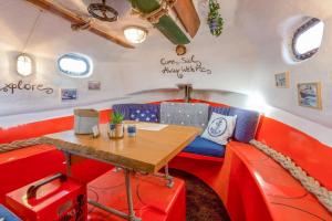 un comedor con mesa y cabinas rojas en PolarStern - unique boatstay!, en Monnickendam
