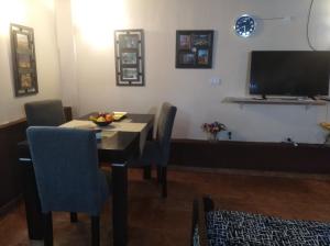 Apartamento Nuevo Centro في قرطبة: غرفة طعام مع طاولة وتلفزيون