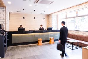 um homem a passar por um balcão de recepção num restaurante em Meet Inn Narita em Narita