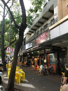 a building with yellow tables and chairs on a street at Edifício Río Mar in Foz do Iguaçu
