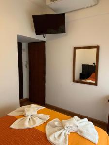 een slaapkamer met 2 handdoeken op een bed met een spiegel bij BALOO Hotel in Mar del Plata