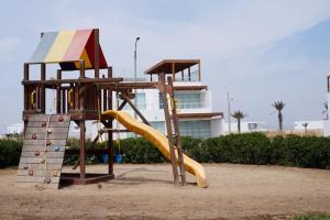 un parque infantil con un tobogán en la arena en Casa 18 en Nuevo Paracas, Condominio Privado, en Paracas