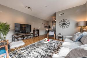 a living room with a couch and a flat screen tv at Trendy Castleberry Hill Condo- Walk to Mercedes Benz/ All Downtown Attractions in Atlanta