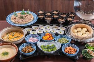 Alpico Plaza Hotel في ماتسوموتو: طاولة مليئة بالأطباق بأنواع مختلفة من الطعام