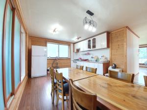 a kitchen with a large wooden table and a dining room at Olle -nang in Jeju