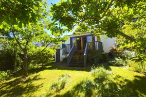 ein Haus mit einer Veranda und einer Treppe im Hof in der Unterkunft Mintie Cottage on Leura Mall in Leura