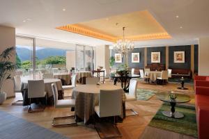 una sala da pranzo con tavoli e sedie e un lampadario di THE HIRAMATSU HOTELS & RESORTS SENGOKUHARA HAKONE a Hakone