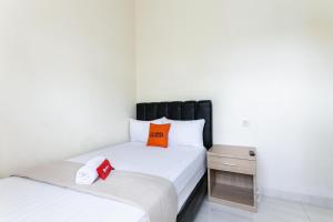 1 dormitorio con 2 camas y mesita de noche en RedDoorz Syariah near Purwosari Train Station en Solo