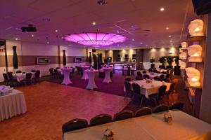 a banquet hall with tables and chairs and a chandelier at Hotel De Zoete Inval Haarlemmerliede in Haarlem