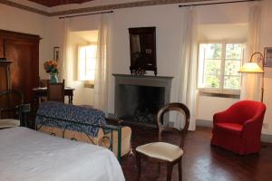 a bedroom with a bed and a fireplace and a chair at Il Maggese in Cortona