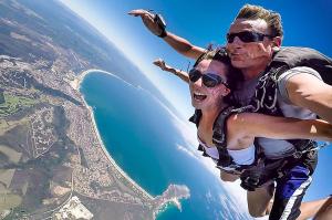 a man and a woman are flying over the water at Plett Beachfront Guest House in Plettenberg Bay