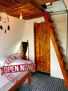 a bedroom with a sign that reads open now at La Luna Cabins in Nuwara Eliya +9 photos