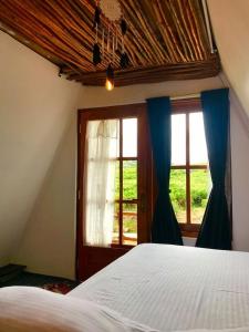 a bedroom with a bed and a window at La Luna Cabins in Nuwara Eliya