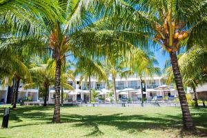 a group of palm trees in front of a hotel at Villas Mon Plaisir in Pointe aux Piments