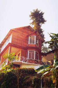 una gran casa roja en la cima de una colina en Kalimpong Village Retreat, en Kalimpong