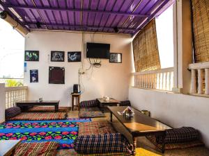 ein Zimmer mit Sofas, Tischen und einem Fernseher in der Unterkunft Hotel Zoola Palace in Pushkar