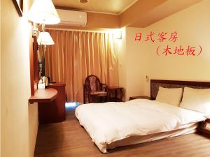 A bed or beds in a room at Hsinchu Shih business hall