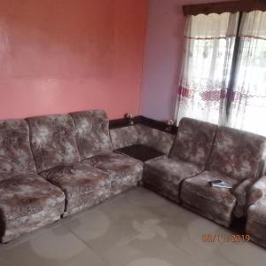 a brown leather couch in a living room with a window at Classixx Inn in Nausori