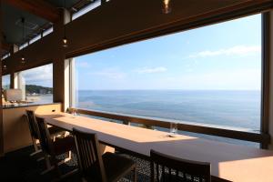 ein großes Fenster in einem Restaurant mit einem Tisch und Stühlen in der Unterkunft Umiakari in Himi