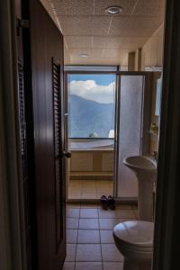 a bathroom with a toilet and a view of a mountain at Le Retour Du Printemps Villa in Ren'ai