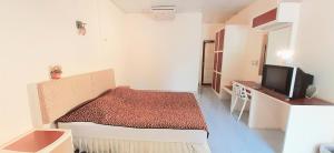Habitación pequeña con cama y TV. en Rai Win Resort en Krabi