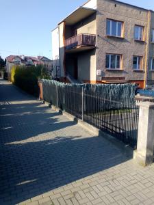 a fence in front of a building at Noclegi Grota in Jasło