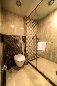 a bathroom with a toilet and a glass shower at Vivanta Jamshedpur, Golmuri in Jamshedpur