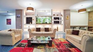 a living room with two couches and a coffee table at Plaza Inn Batumi in Batumi