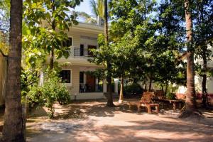 シオリムにあるDSK Studio Apartment, Siolim, Goa.のピクニックテーブルと木々が目の前にある家
