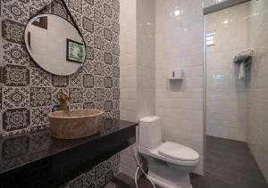 een badkamer met een wastafel, een toilet en een spiegel bij Le Printemps d' An Bang in Hội An