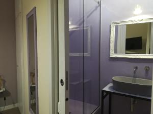 Baño púrpura con lavabo y espejo en Persiane al Cassaro en Palermo