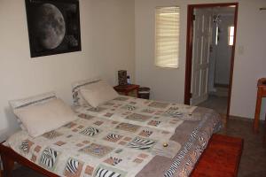a bedroom with a bed with a blanket on it at Rooisand Desert Ranch in Chausib