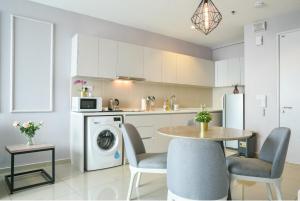 a kitchen with a table and chairs and a laundry machine at Q Suite at i-City in Shah Alam