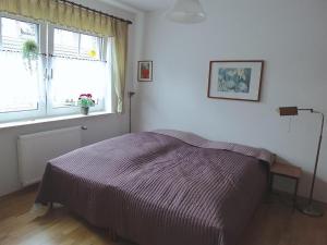 a white bedroom with a bed and a window at Ferienwohnung Ruwald in Bad Zwischenahn