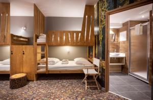 a room with two bunk beds and a shower at Hotel Base Camp Lodge - Bourg Saint Maurice in Bourg-Saint-Maurice