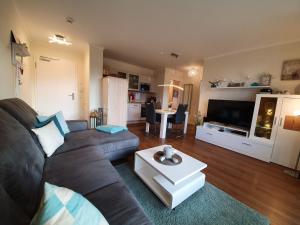 a living room with a couch and a table at FeWo Baltic Sky in Börgerende-Rethwisch