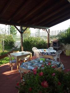 a patio with a table and chairs under a pavilion at Villa Itaca in Sant'Isidoro