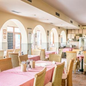 a restaurant with tables and chairs with pink table cloth at Motorest Eso in Vlčkovce