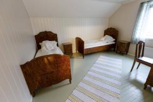 a room with two beds and a rug at Elfridastua in Sørvær