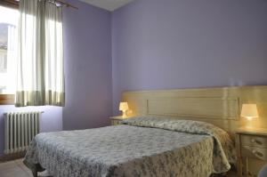 a bedroom with a bed and two lamps and a window at Hotel Regina in Florence