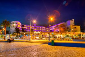 a building with purple lights on it at night at Limanaki Beach Hotel & Suites in Ayia Napa