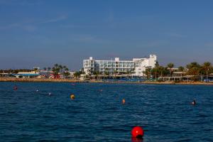 a large body of water with a building in the background at Limanaki Beach Hotel & Suites in Ayia Napa