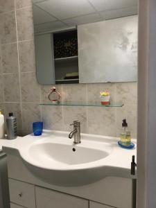 W łazience znajduje się biała umywalka i lustro. w obiekcie Chez DouKine w mieście Beure