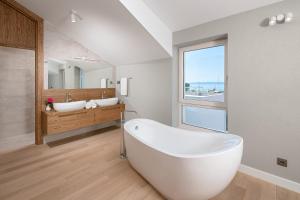 a bathroom with a large white tub and two sinks at Villa Basca in Baška Voda