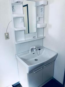 a bathroom with a white sink and a mirror at 一棟貸しの海宿 Kamakura SUN&BREEZE in Kamakura +13 photos