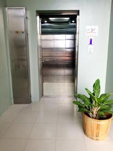 um corredor com elevador e um vaso de plantas em La Anclar Hotel em Dávao