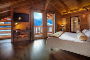 ein Schlafzimmer mit einem Bett und einem großen Fenster in der Unterkunft Chalet Stellaone - OVO Network in La Clusaz
