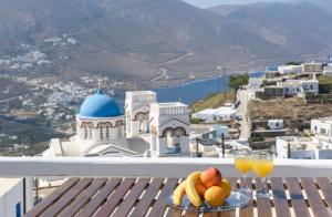 a plate of fruit and drinks on a table on a balcony at Plori Studios and Apartments in Aegiali