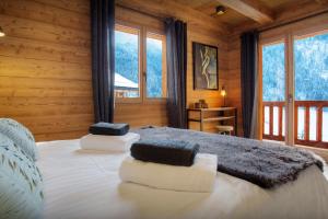 ein Schlafzimmer mit einem Bett in einem Blockhaus in der Unterkunft Chalet Stellaone - OVO Network in La Clusaz