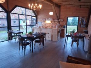 a kitchen and dining room with tables and chairs at Pipowagen Lidewei Groningen Westerwolde unieke ligging met eigen tuin en vrij uitzicht over veld naar natuurgebied in Onstwedde